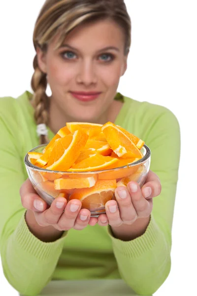 白い背景の上のオレンジを持つ女性はオレンジ色に焦点を当てる — ストック写真