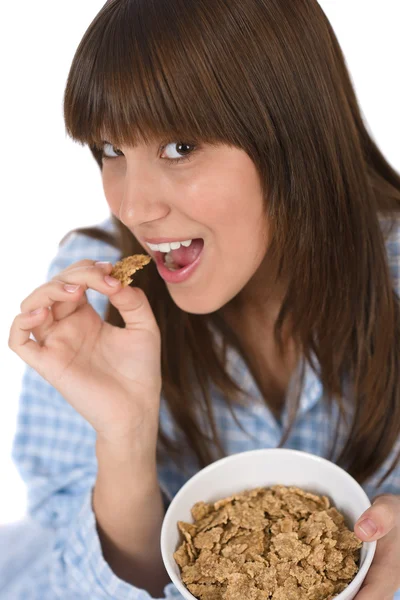 Adolescente femenina come cereales saludables para el desayuno — Foto de Stock