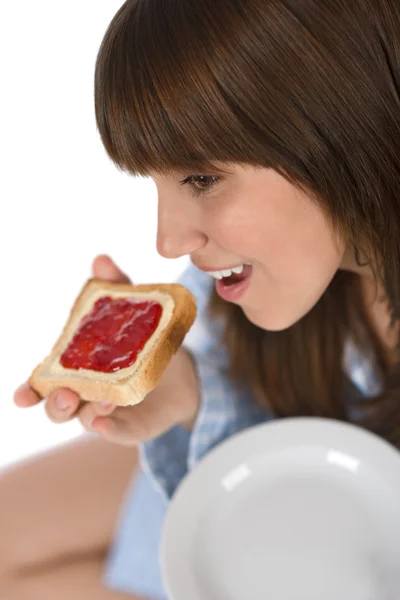Adolescente feliz en pijama comiendo tostadas saludables —  Fotos de Stock