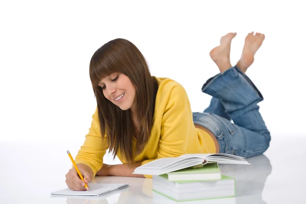 青少年快乐女生在白色背景上写的家庭作业 — 图库照片