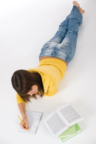 Студент - жінка-підліток пише домашнє завдання з книгою — стокове фото