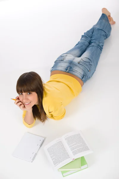 青少年快乐女生在白色背景上写的家庭作业 — 图库照片