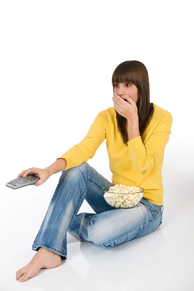 Surprised Female Teenager Watching Television Holding Remote Control Eating Popcorn — Stock Photo, Image