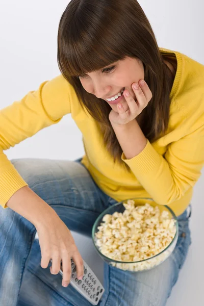 Szczęśliwy Nastolatek Kobiece Oglądania Telewizji Trzymając Pilot Zdalnego Sterowania Jedzenie — Zdjęcie stockowe