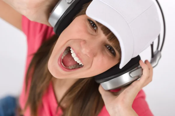Adolescente feminina cantando com fones de ouvido — Fotografia de Stock
