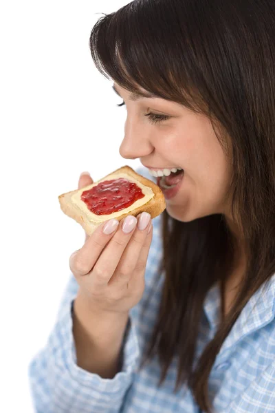 微笑的女人穿着睡衣在白色背景上早饭吃健康烤面包 — 图库照片