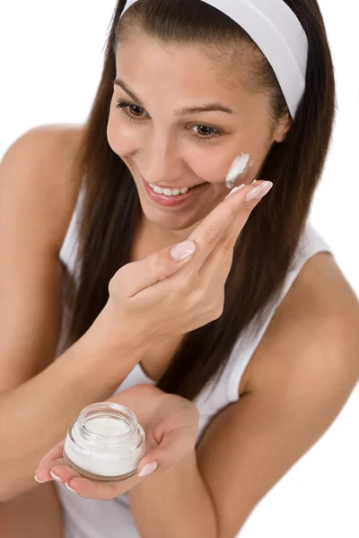 Schönheitspflege - junge Frau trägt Feuchtigkeitscreme auf — Stockfoto