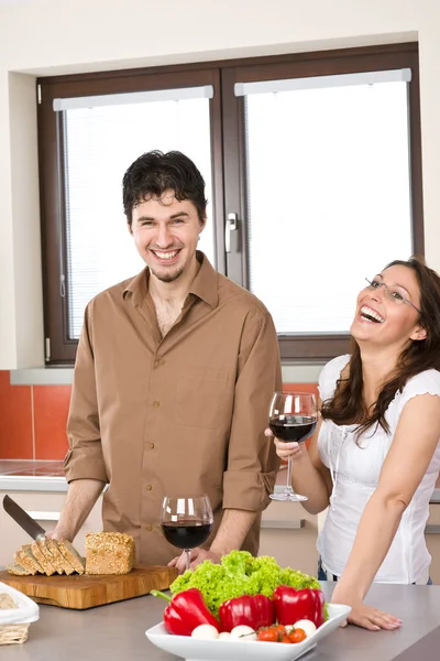 Ευτυχισμένο ζευγάρι στην σύγχρονη κουζίνα πίνουμε κόκκινο κρασί — Φωτογραφία Αρχείου