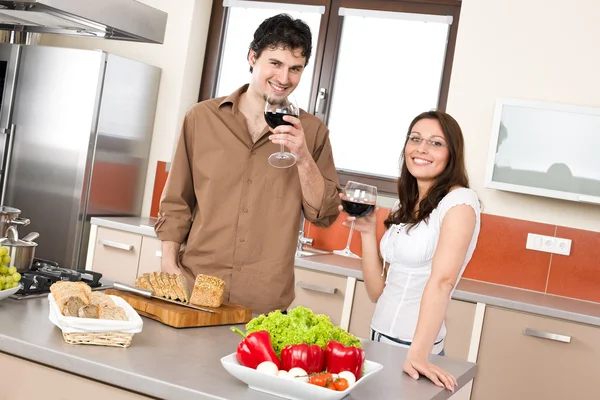 幸福的夫妻在一起切在现代厨房中的面包和喝红酒 — 图库照片