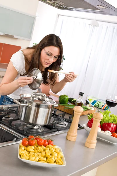 野菜とパスタと近代的なキッチンで若い女性 — ストック写真