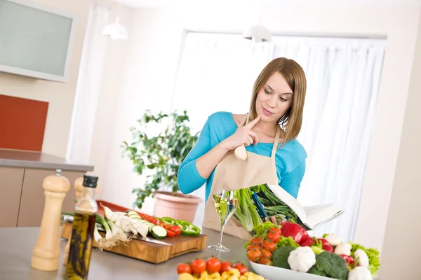 Cooking - Woman reading cookbook in kitchen — Stock Photo, Image