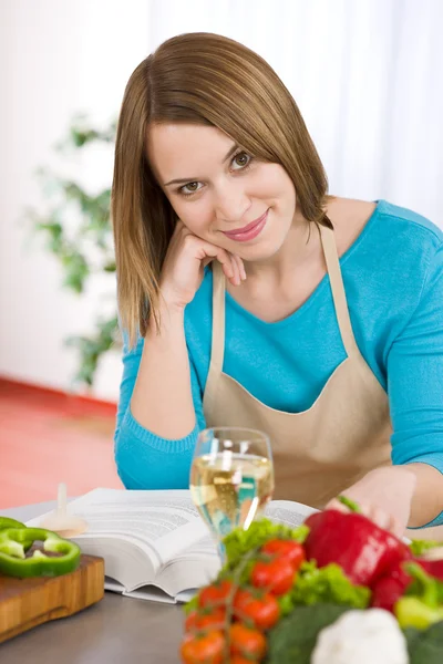 キッチン パスタと野菜の白ワインのガラスを持つ女性の笑みを浮かべて — ストック写真