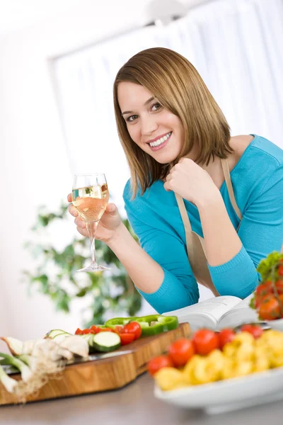 Μαγειρική - χαμογελώντας γυναίκα με ποτήρι λευκό κρασί — Φωτογραφία Αρχείου