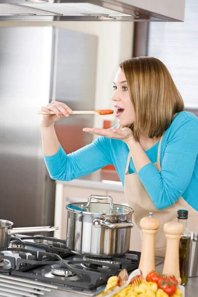 Cozinhar - Mulher degustação de molho de tomate italiano na cozinha moderna — Fotografia de Stock