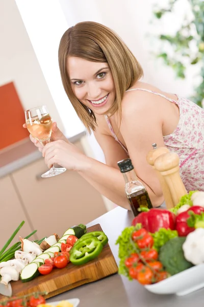 Vaření - usmívající se žena s sklenici bílého vína a zeleniny — Stock fotografie