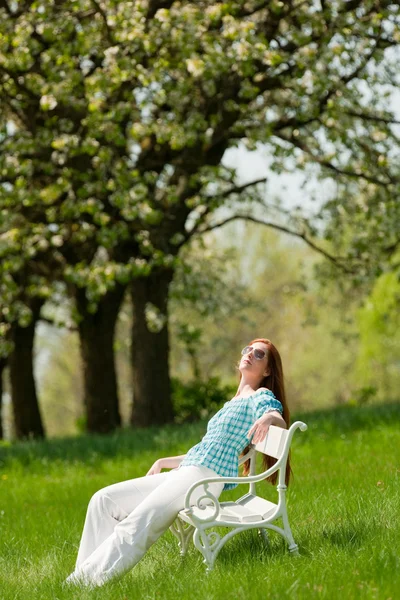 Jeune femme relaxante sous un arbre en fleurs au printemps — Photo