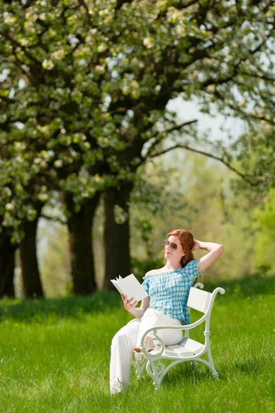 Рыжеволосая Женщина Читающая Белую Книгу Скамейке Лугу Мелкий Dof — стоковое фото