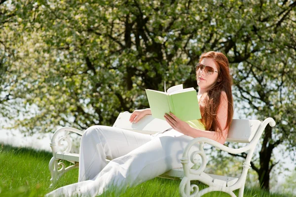 Young woman relaxing under blossom tree in spring — Stock Photo, Image