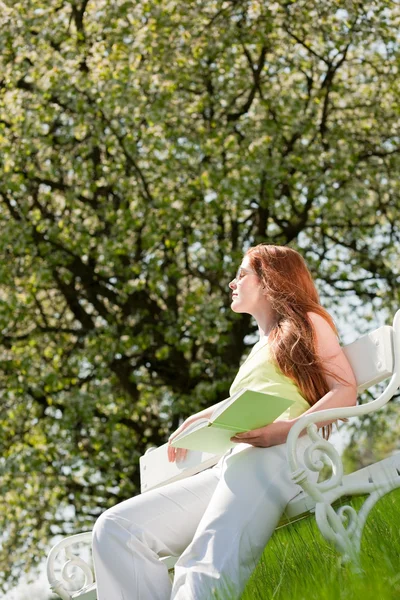 Młoda kobieta relaksujący pod drzewem kwitnąć wiosną — Zdjęcie stockowe
