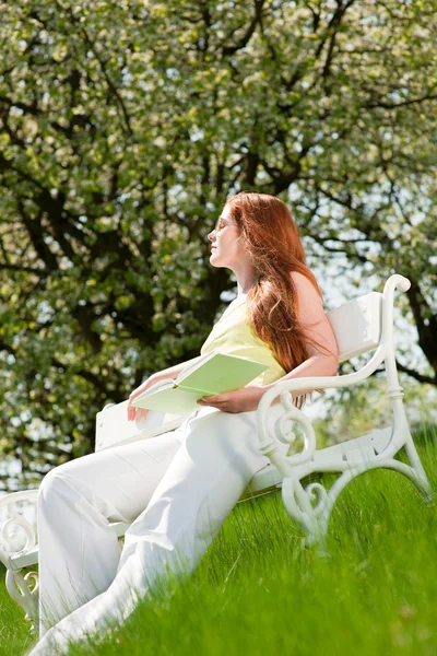 年轻女人放松下桃花树在春天 — 图库照片
