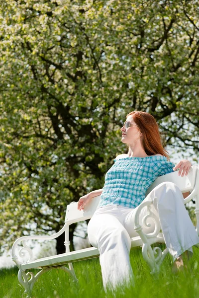 Mladá žena relaxační pod stromem květy na jaře — Stock fotografie