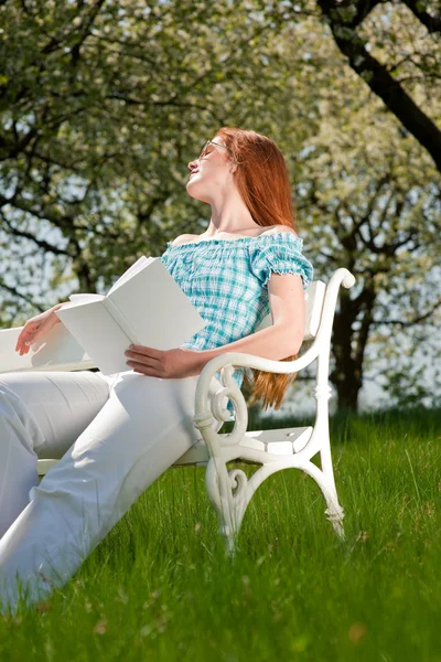 Молодая женщина отдыхает под цветущим деревом весной — стоковое фото