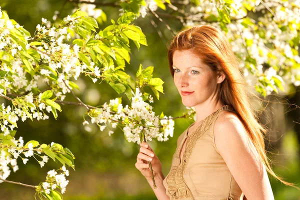 Молодая женщина наслаждается весной под цветущим деревом — стоковое фото