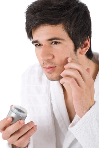 Pielęgnacja twarzy - młody człowiek stosując balsam — Zdjęcie stockowe