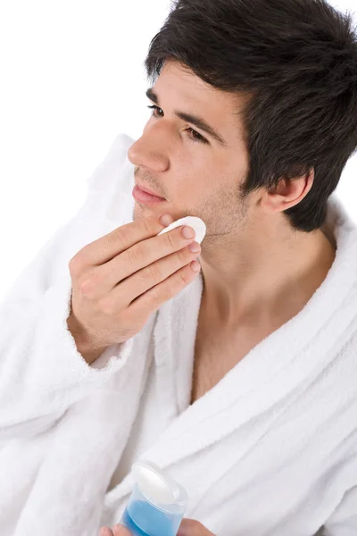 Cuidados faciais - Jovem limpeza rosto com loção — Fotografia de Stock