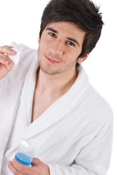 顔のケア 若者が白い背景の上のローションとの顔の洗浄 — ストック写真