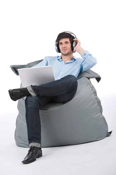 Jovem empresário relaxar com música e laptop — Fotografia de Stock
