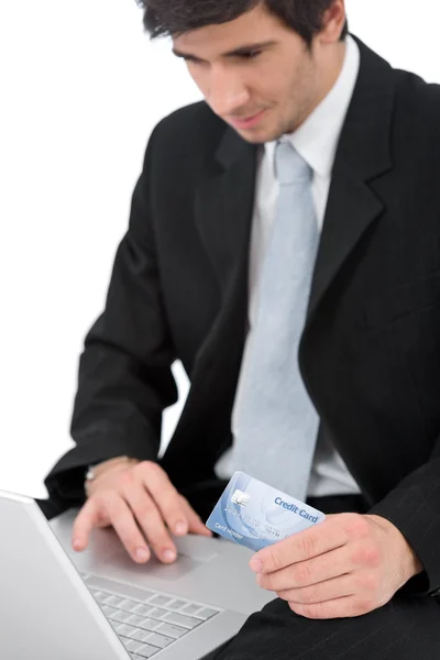 年轻的商人用白色背景 侧重于卡上持有信用卡的笔记本电脑 — 图库照片