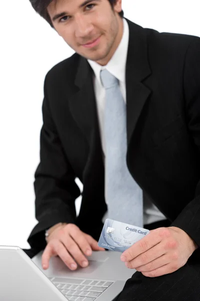 Giovane uomo d'affari con laptop in possesso di carta di credito — Foto Stock