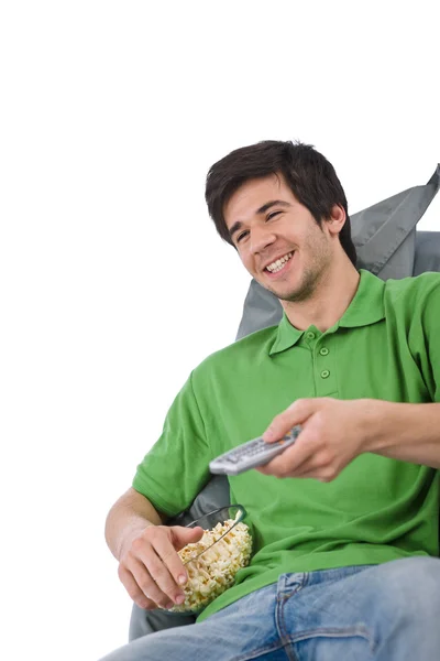 年轻男子举行远程控制看电视和在白色背景上吃爆米花 — 图库照片