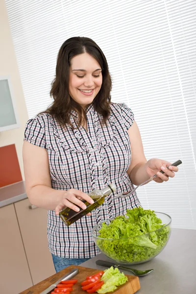 クック プラス サイズの幸せな女の近代的なキッチンでレタスとサラダを準備します — ストック写真