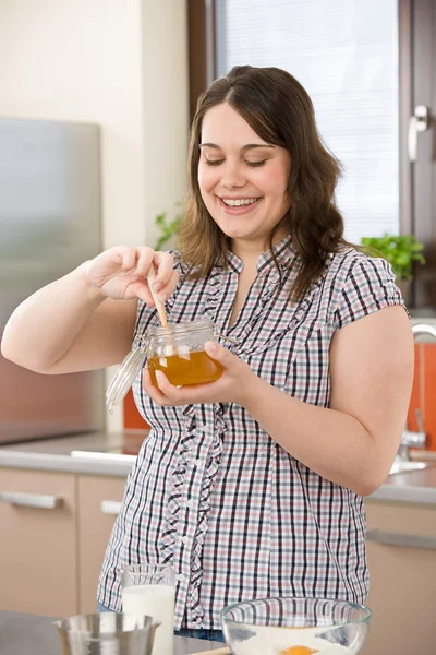 Bake - happy woman with ingredients in kitchen — Stock Photo, Image