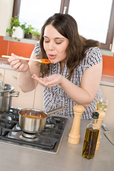 プラスサイズの女性現代台所でイタリアのトマトソース味 調理します — ストック写真
