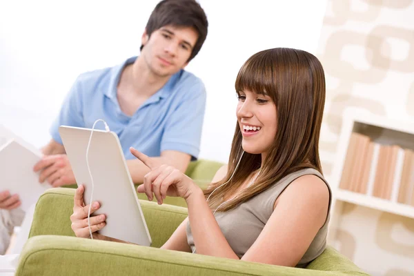 少女女人在休息室和男人在一起的扶手椅上触摸屏平板电脑 — 图库照片