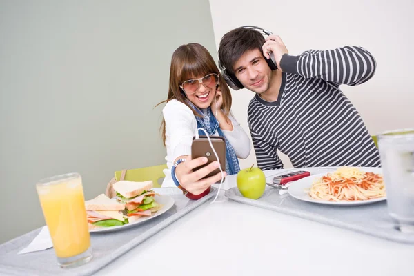 Student cafeteria - teenage couple having fun with music — Stock Photo, Image