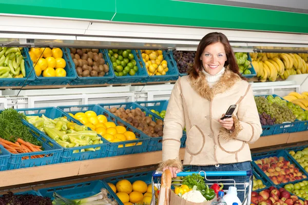 Élelmiszer-áruház, vásárlás - mosolygó nő-val mozgatható telefon — Stock Fotó