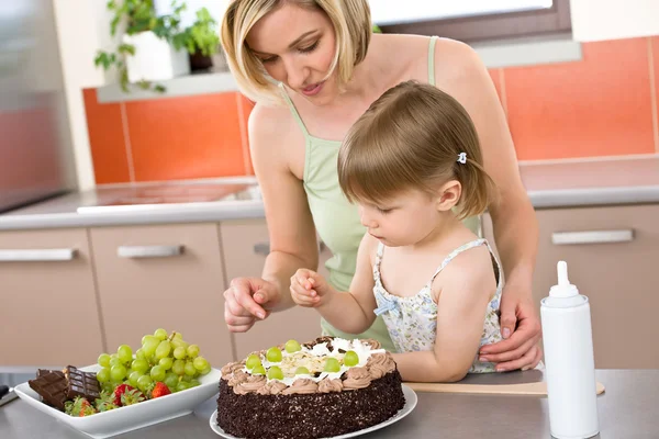 母亲和儿童提供在厨房里的巧克力蛋糕 — 图库照片