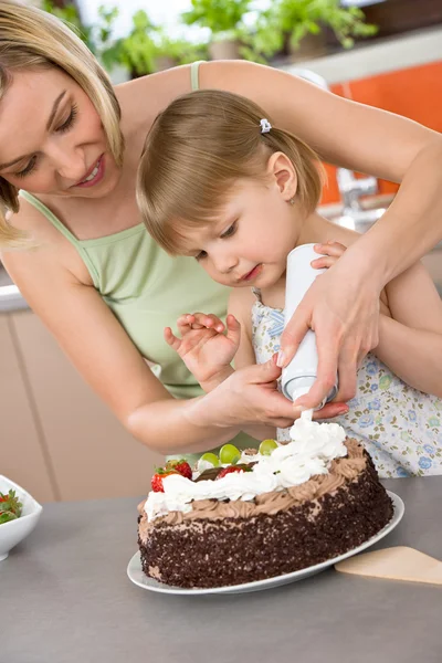 Μητέρα και παιδί με κέικ σοκολάτας στην κουζίνα — Φωτογραφία Αρχείου