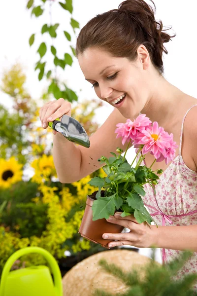 Садоводство - женщина держит цветочный горшок и лопату — стоковое фото