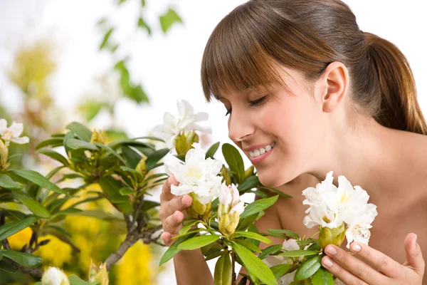 Portrait of woman smelling blossom of Rhododendron flower — Stock Photo, Image