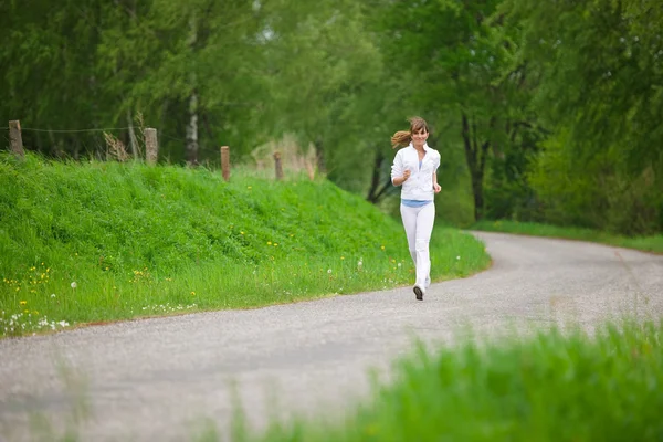 Bieganie - sprawny kobieta działa na drodze w przyrodzie — Zdjęcie stockowe