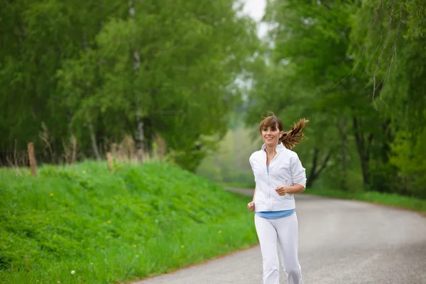 Jogging - sportive woman running on road in nature — Stock Photo, Image