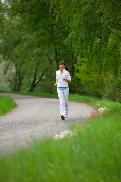 Jogging Sportowa Kobieta Biegająca Drodze Naturze Słuchająca Muzyki Słuchawkami — Zdjęcie stockowe