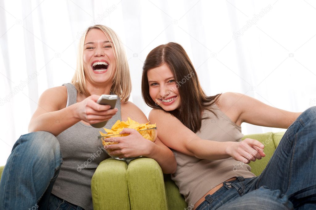 Two teenage girls having fun by television