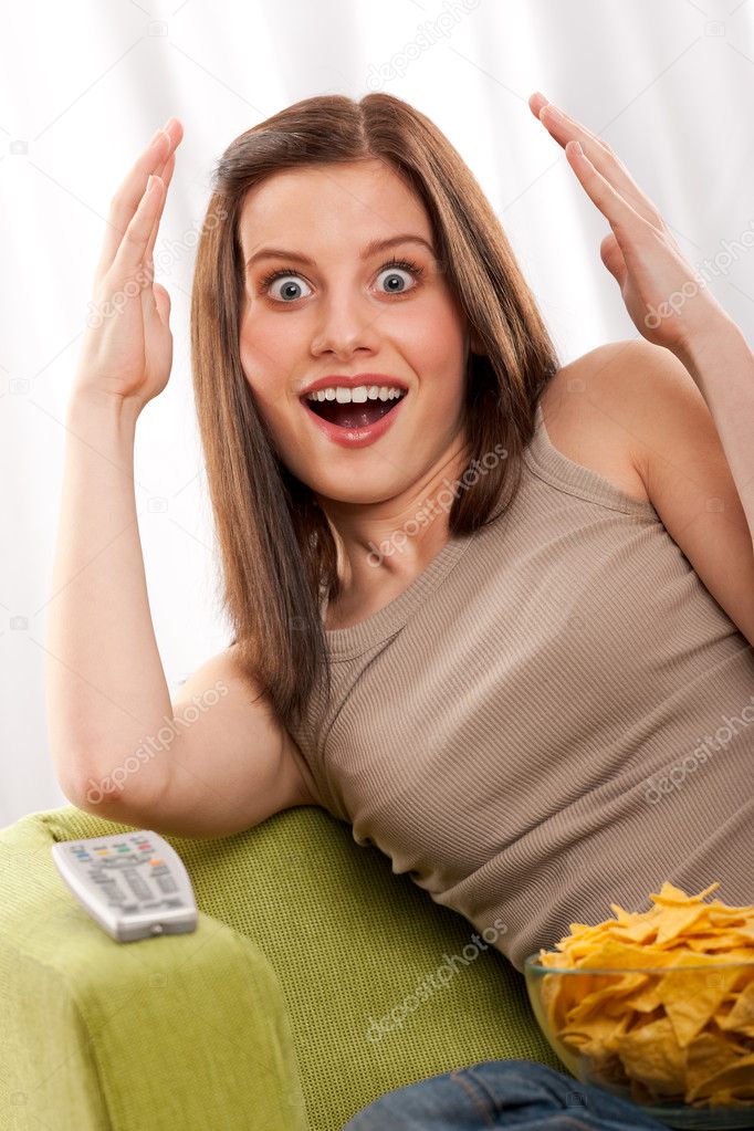 Young brown hair woman surprised by watchnig television