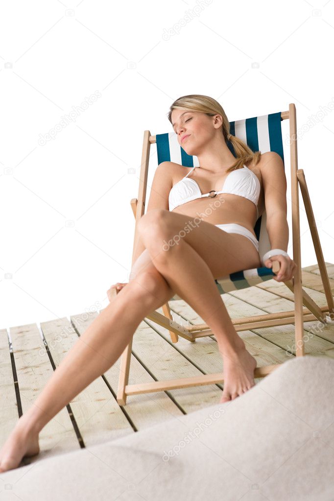 Beach - woman in bikini lying on deck chair